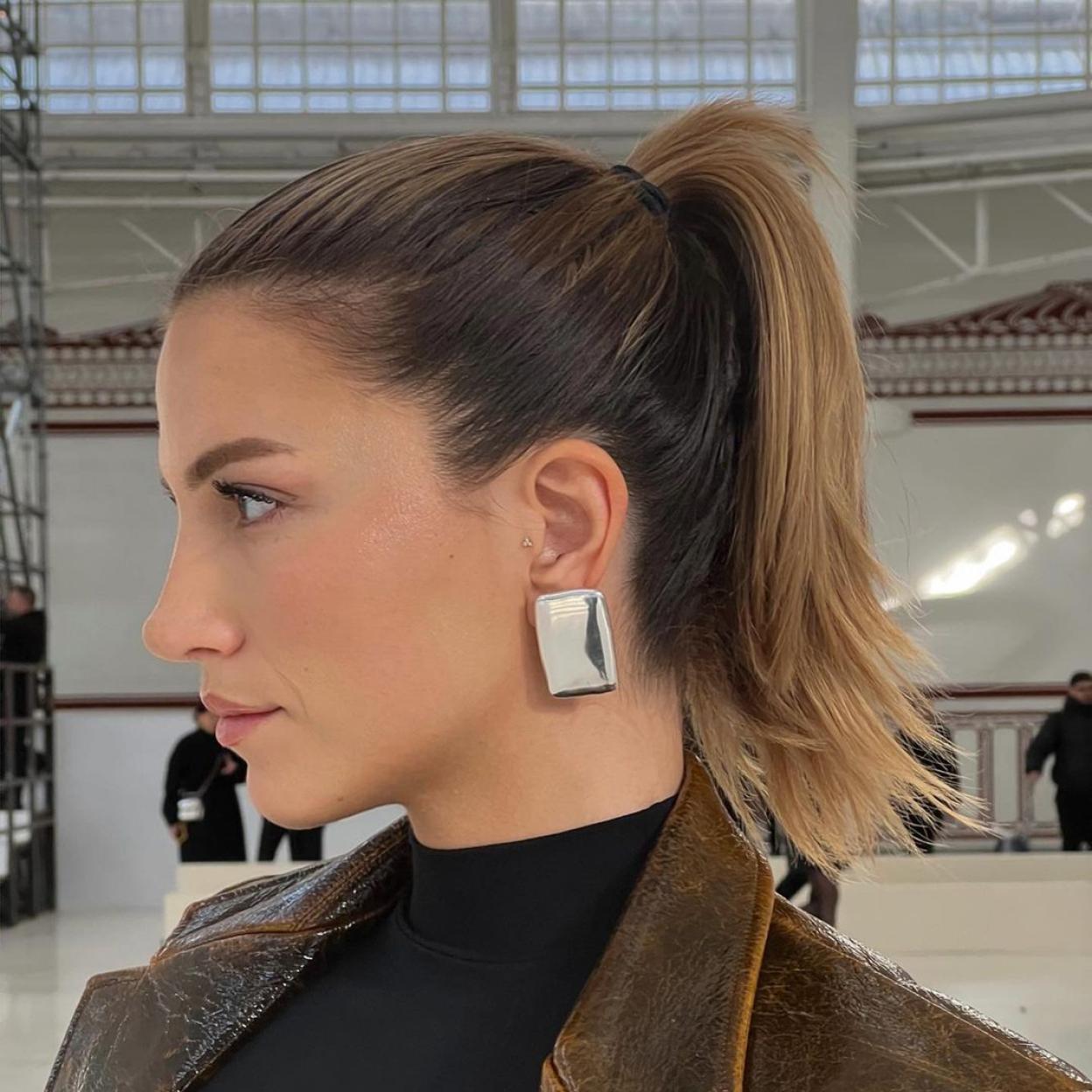 Una mujer con pendientes plateados.