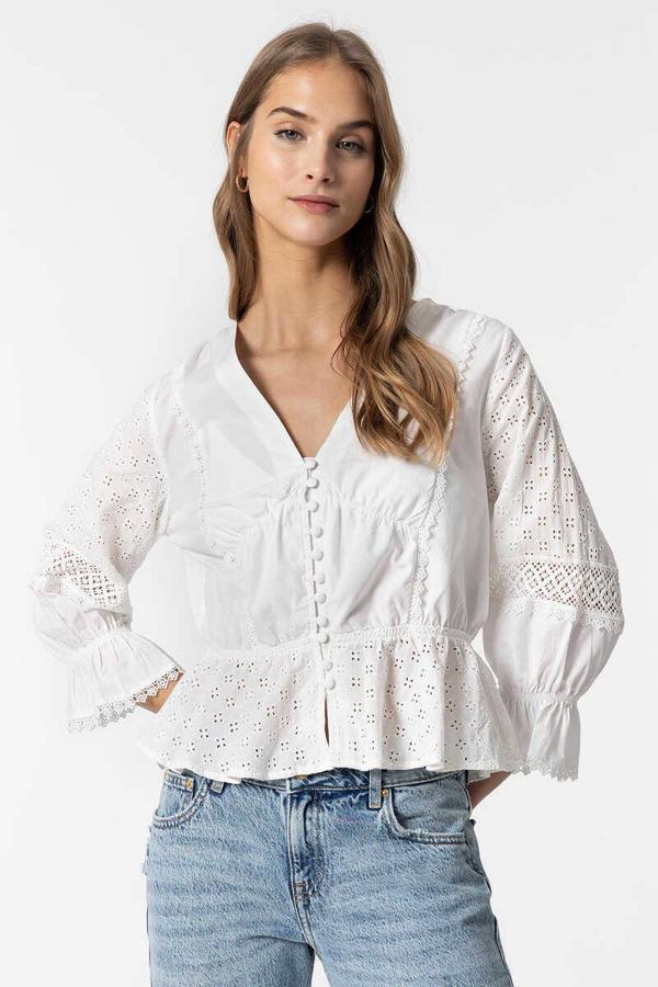 Blusa con bordado inglés, cuello de pico, manga y bajo terminado en volante, de Tiffosi. Su precio es de 29,99 euros, en Springfield.