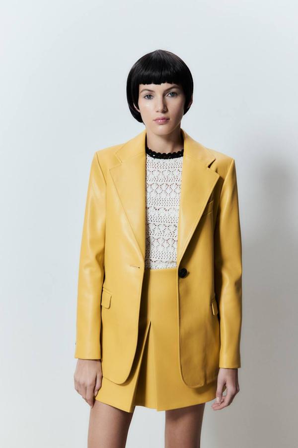Blazer efecto piel con cuello solapa con muesca, manga larga, tres bolsillos y cierre simple por botón, en amarillo. Cuesta 59,99 euros.