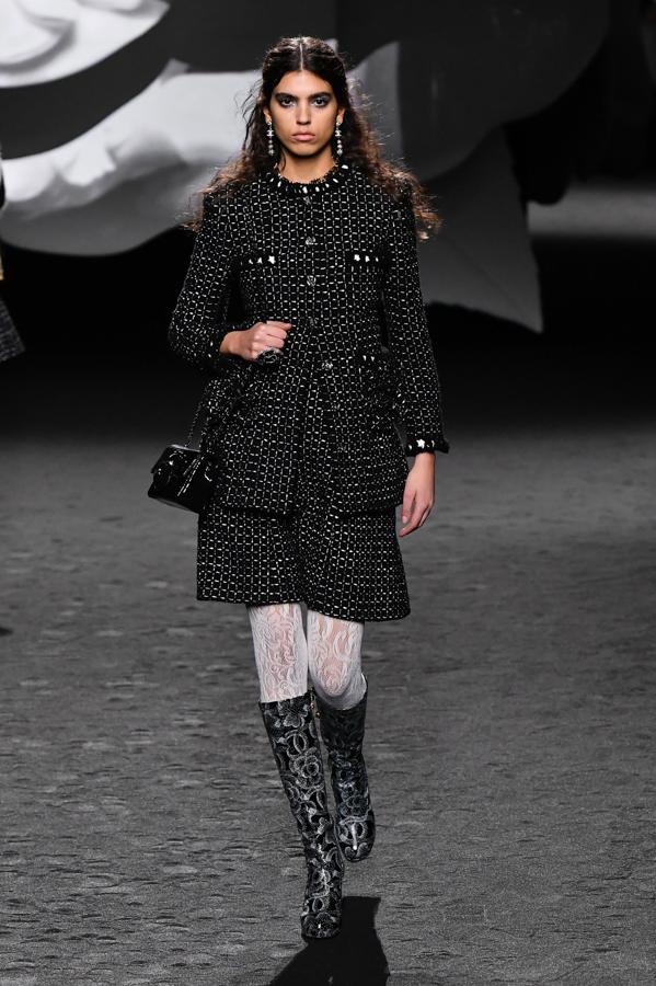El color negro se presenta mediante un aire elegante en looks de tweed, tejido icónico de la firma. 
