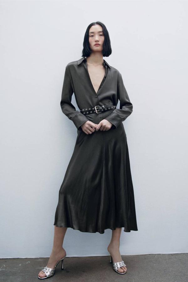 Falda midi satinada con tiro alto y bajo acabado en evasé, color negro, de Zara. Hazte con ella a 29,95 euros.