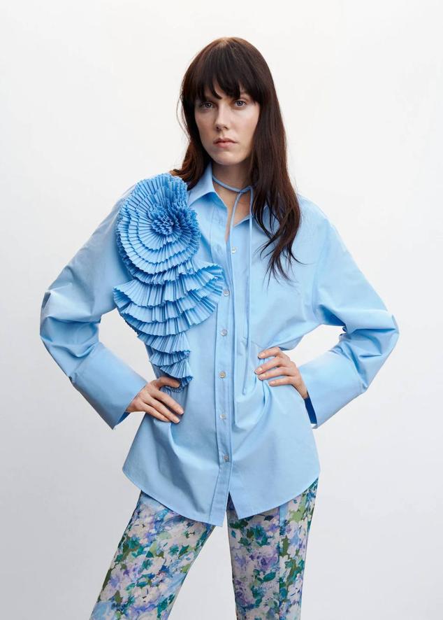 Camisa oversize con cuello solapa, manga larga, cierre de botones y detalle de maxi flor plisada, en azul, de Mango. Hazte con ella a 49,99 euros.