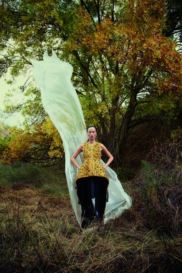 Top de tweed dorado con maxibotones y vestido de punto gris, ambos de Louis Vuitton.