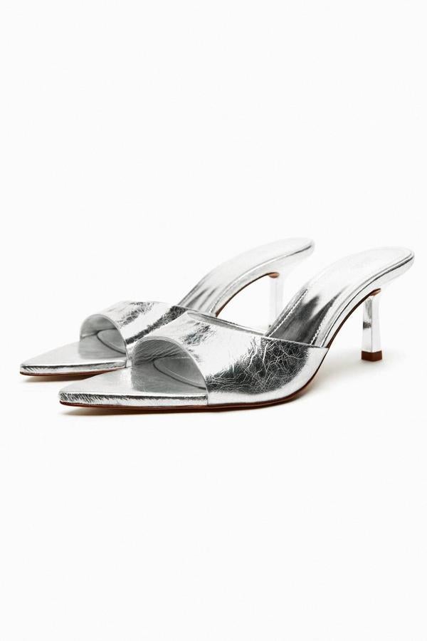 Mules de tacón bajo con diseño destalonado y acabado en punta, en tejido efecto piel craquelada plata, de Zara. Hazte con ellos por 45,95 euros.