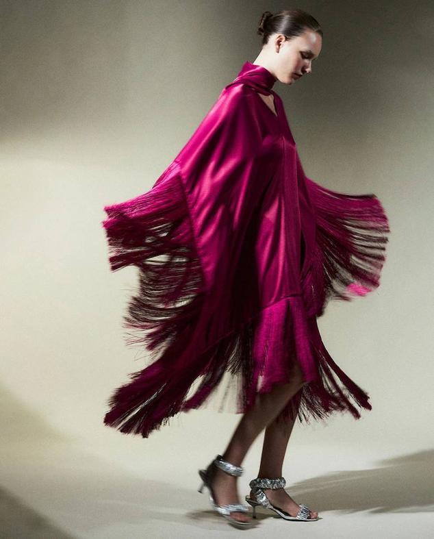 Vestido midi satinado con escote de pico, lazada al cuello y terminaciones de flecos, color frambuesa, de Sfera. Hazte con él a 59,99 euros.