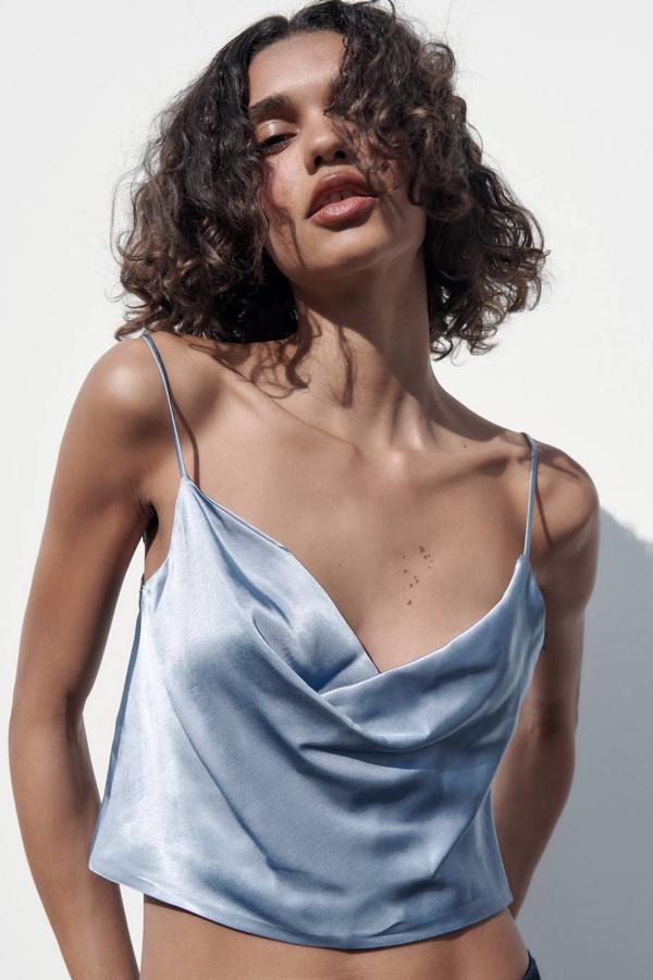 Top en tejido satinado con escote drapeado y tirantes finos ajustables, en azul, de Zara. Puedes comprarlo por 19,95 euros.