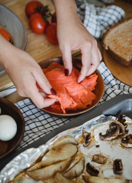 Imagen - Mujer cocinando con salmón/PEXELS