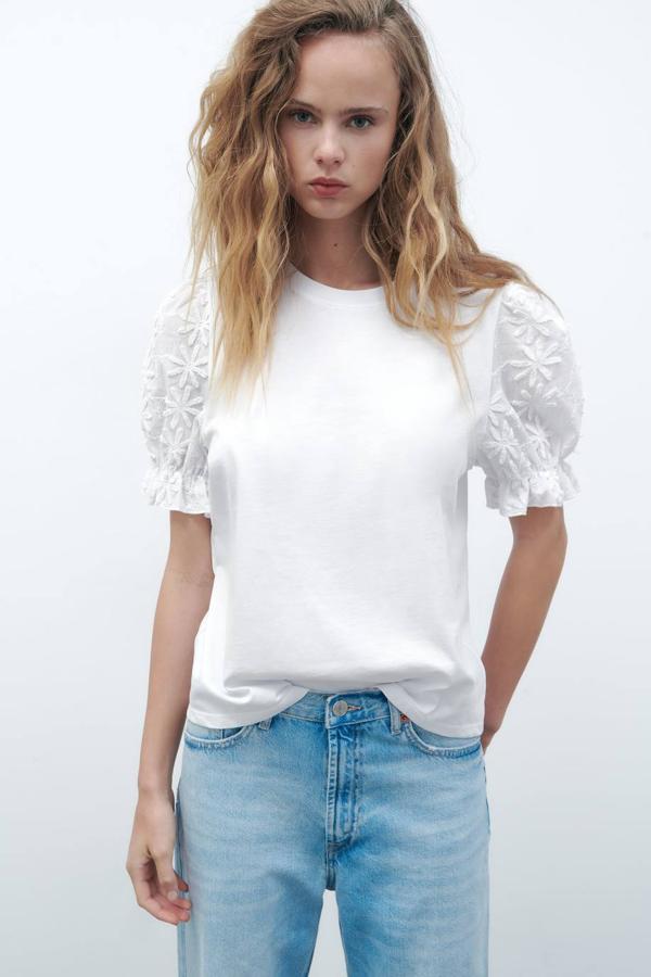 Camiseta con cuello redondo y manga corta abullonada decorada con bordado de flores a tono, en blanco, de Zara. Está disponible a 17,95 euros.