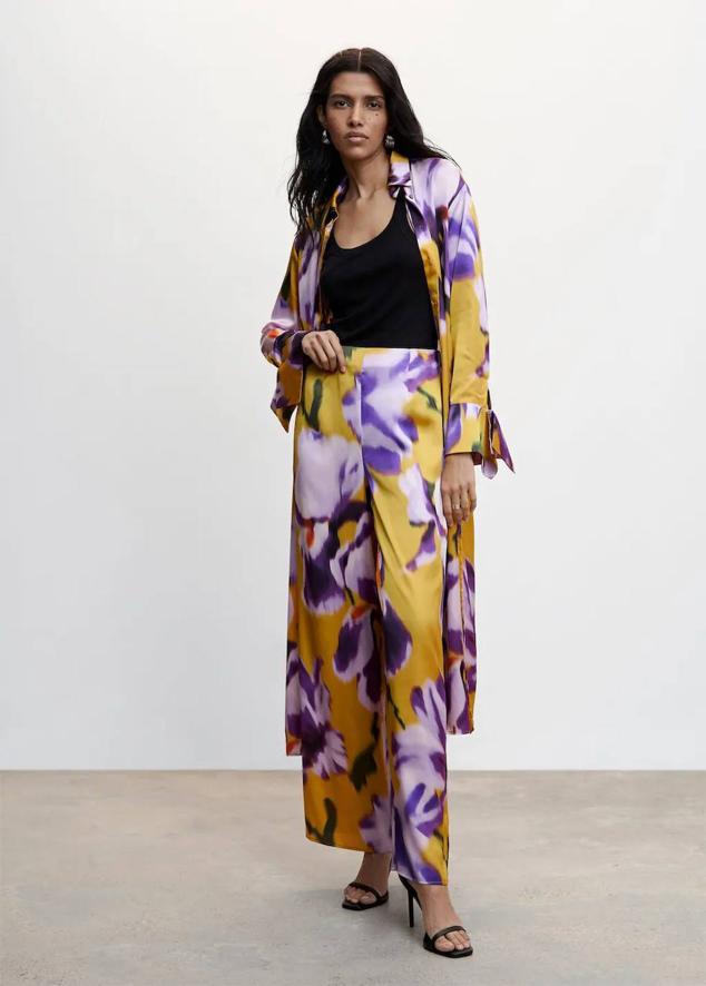 Pantalón en tejido fluido satinado con tiro alto, cintura elástica y maxi estampado floral abstracto en morado y amarillos. Puedes comprarlo a 49,99 euros.