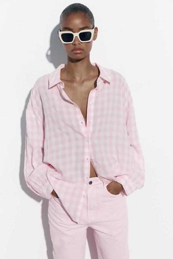 Camisa oversize fluida con corte relajado, manga larga, cuello solapa, cierre de botones y estampado de vichy en rosa claro, de Zara. Consíguela por 25,95 euros.