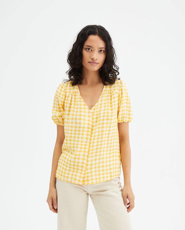 Blusa fluida con manga corta abullonada, escote de pico, cierre de botones y estampado de vichy amarillo, de Compañía Fantástica. Puedes comprarla en El Corté Inglés a 39,95 euros.