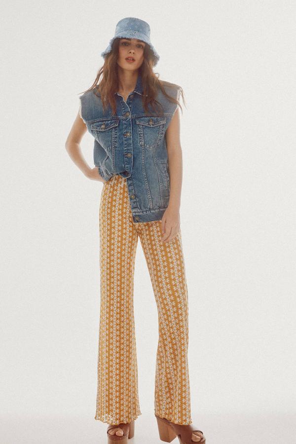 Pantalón de crochet con tiro alto, cintura elástica, perneras rectas y estampado bicolor en amarillo y crudo, de Slowlove. Está disponible en Cortefiel por 49,99 euros.