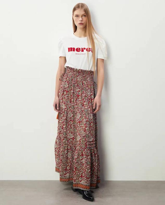 Falda larga con tejido fluido, tiro alto, cintura elástica y detalle de borlas, en estampado floral rojo de Sfera. Puedes encontrarla en El Corte Inglés a 25,99 euros.