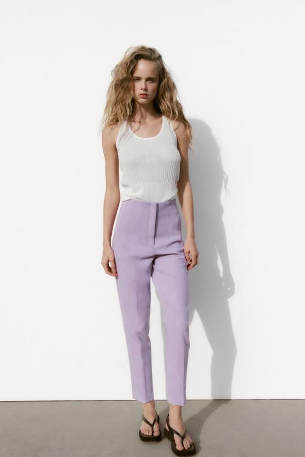 Pantalón de tiro alto con pinzas y perneras acomodadas al cuerpo, tono lila, de Zara. Hazte con él a 25,95 euros.