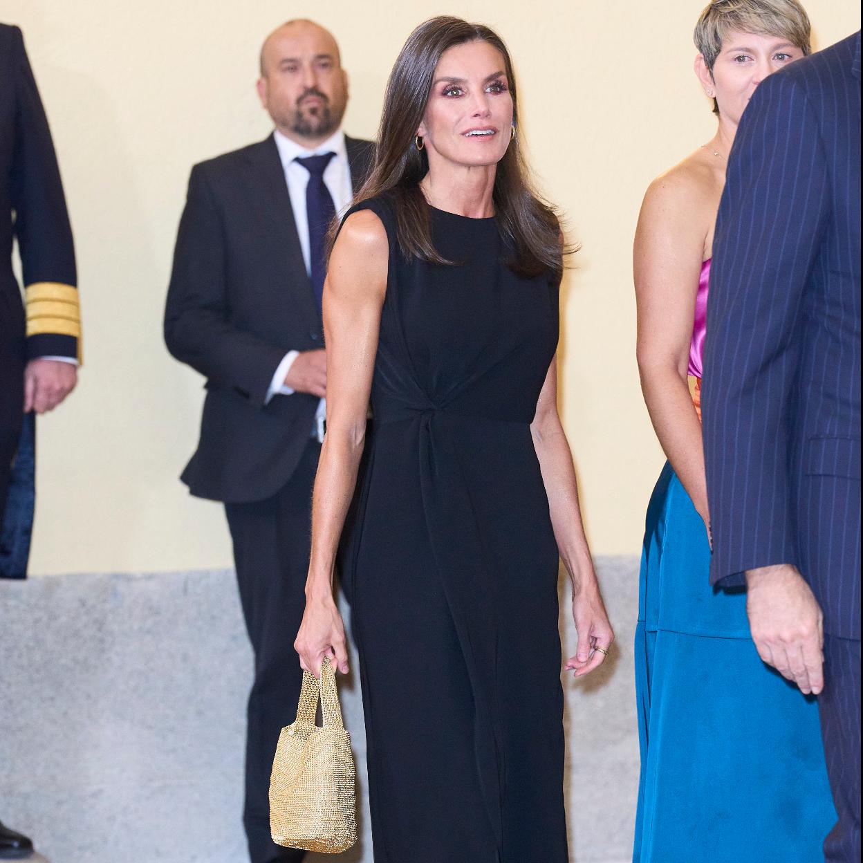 La reina Letizia con un bolso dorado.