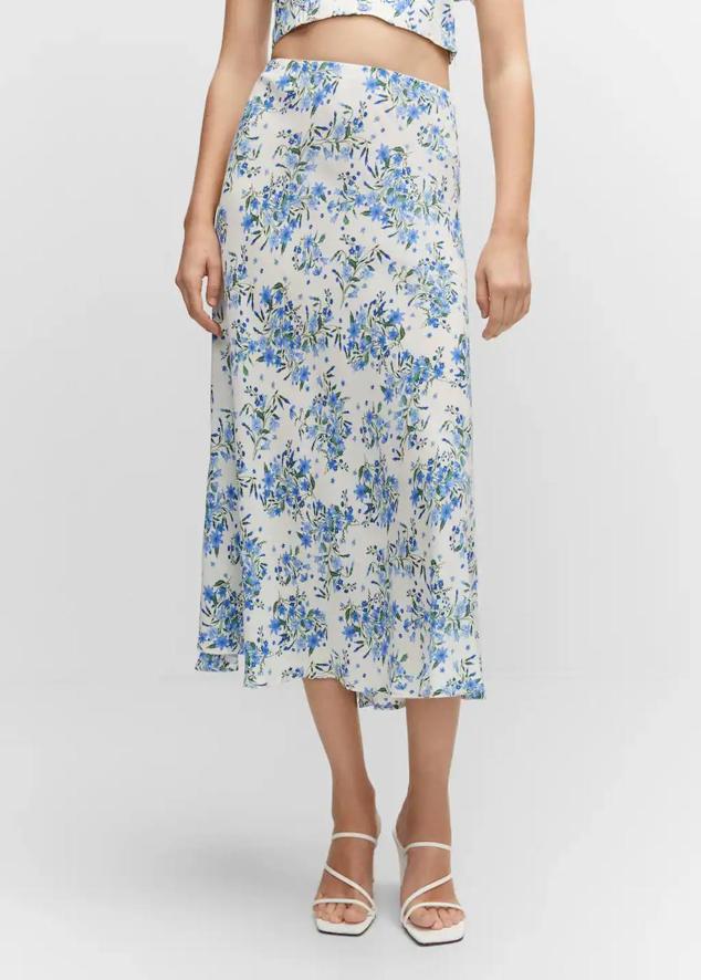 Falda midi en tejido fluido con tiro alto, cintura elástica, bajo acabado en evasé y floral print en blanco y azul, de Mango. Hazte con ella a 25,99 euros.