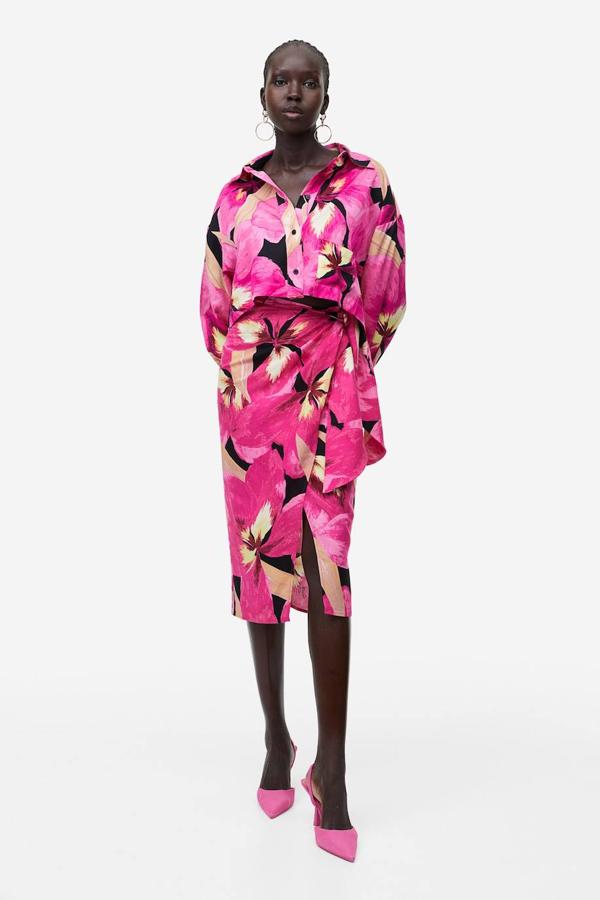 Falda midi tipo pareo en tejido de lino con tiro alto, detalle de lazada, abertura y floral print color rosa, de H&M. Consíguela por 29,99 euros.