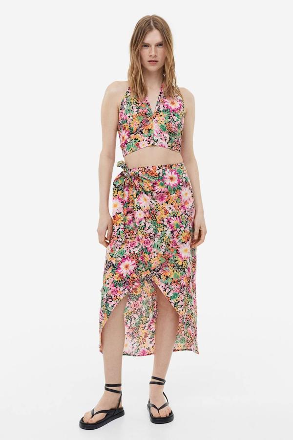 Falda midi cruzada con tiro alto, lazada y abertura, en estampado de flores multicolor, de H&M. Te costará 29,99 euros.