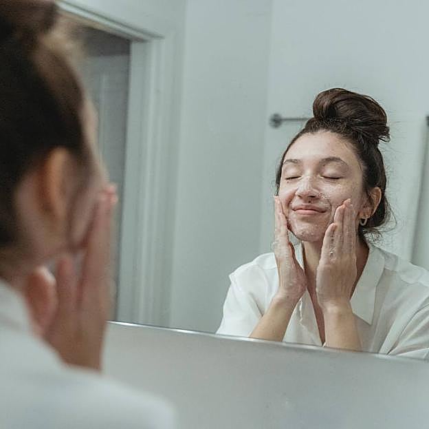 Modelo realizando limpieza facial con jabón