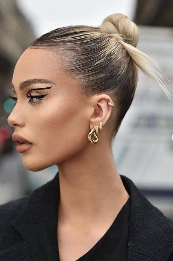 En versión spiky bun o sencilla, es el moño tendencia 2023 por excelencia. Siguiendo la moda del clean look, lo que tenemos que hacer es peinar y alisar muy bien el cabello. Después, lo untaremos en gel fijador o crema y lo peinaremos hacia atrás, muy tirante, para que quede ese efecto pulido y limpio. Hemos una coleta muy sujeta y enrollamos el pelo. También podemos dejar las puntas fuera, y pasarles la plancha para que queden afiladas, rectas y con el acabado puntiagudo.