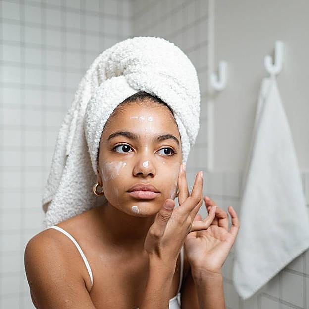 Mujer aplicándose crema hidratante