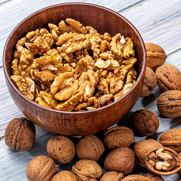 Tazón con nueces peladas y con cáscara. 