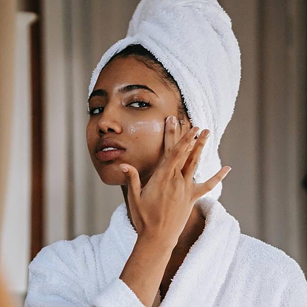 Mujer aplicando vaselina en la cara