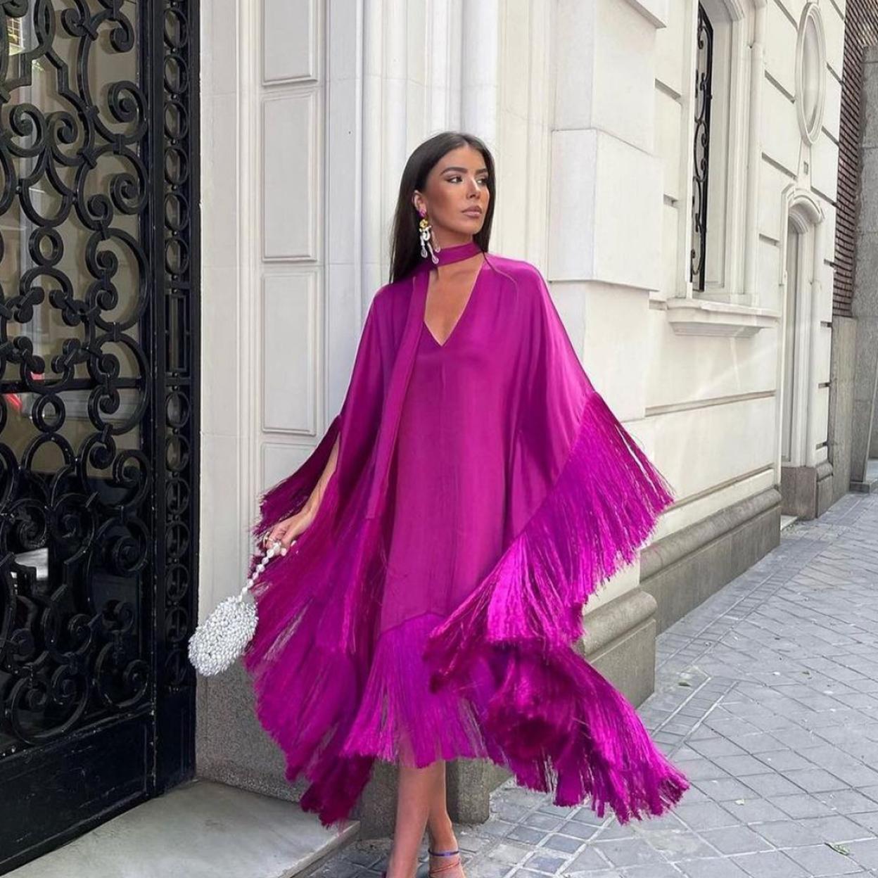 Una mujer con vestido en color fucsia.