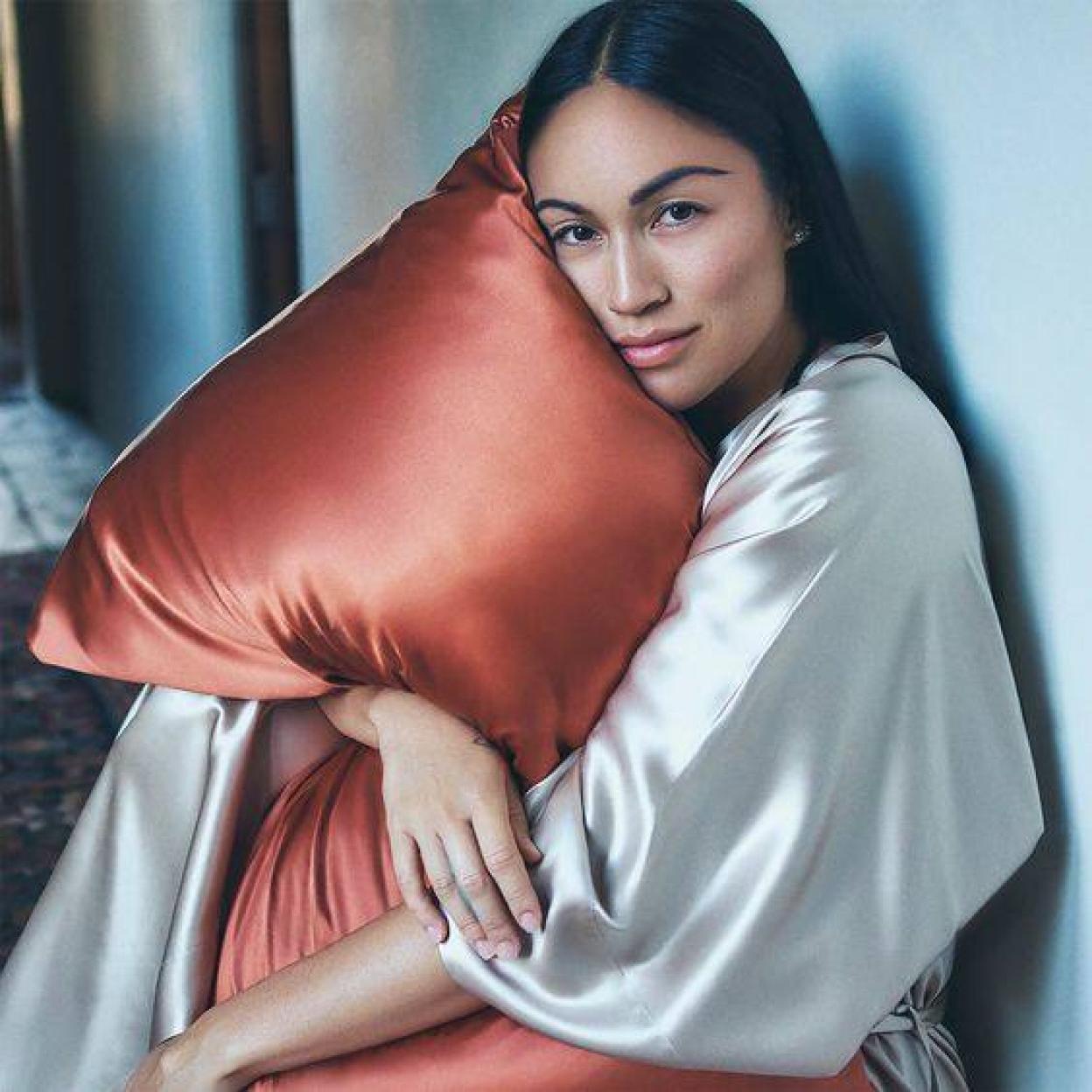 Modelo sujetando almohada con funda de seda
