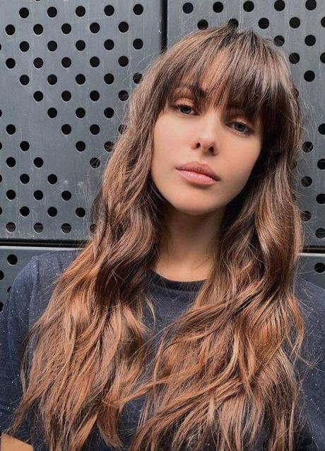Imagen - Mujer con melena larga y flequillo como corte de pelo encrespado