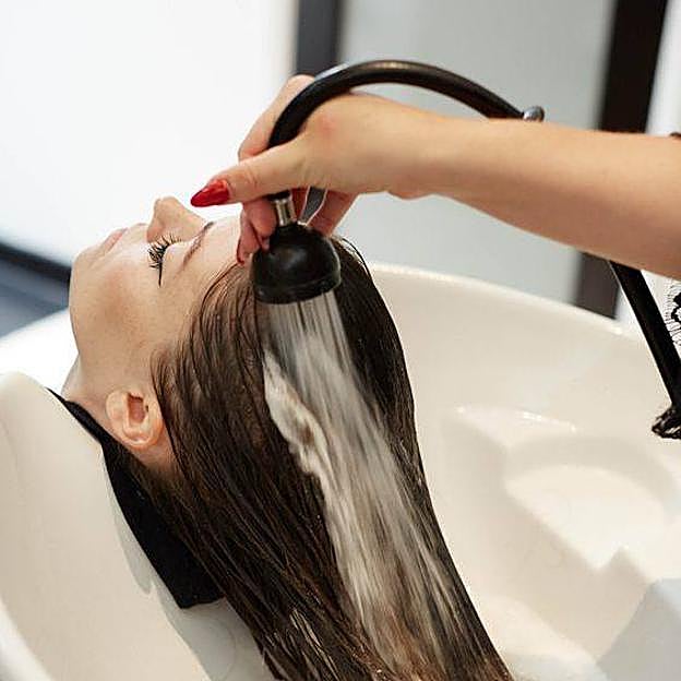 Profesional realizando tratamiento de ácido hialurónico para el pelo