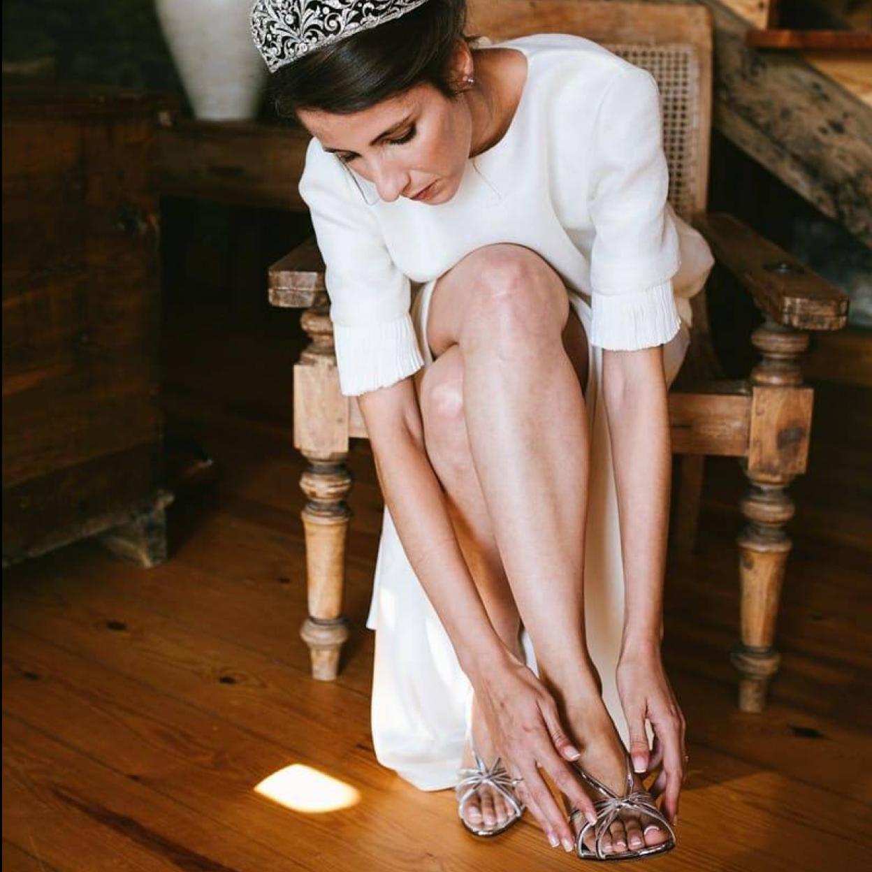 Novia poniéndose zapatos con pedicura hecha