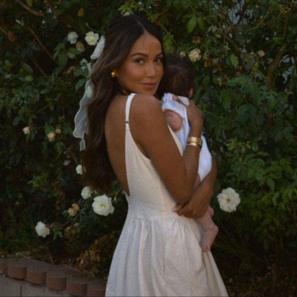 Una influencer con su hijo bebé en brazos.