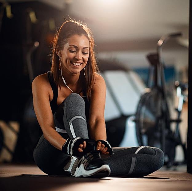 Mujer preparándose para hacer deporte en el gimnasio. 