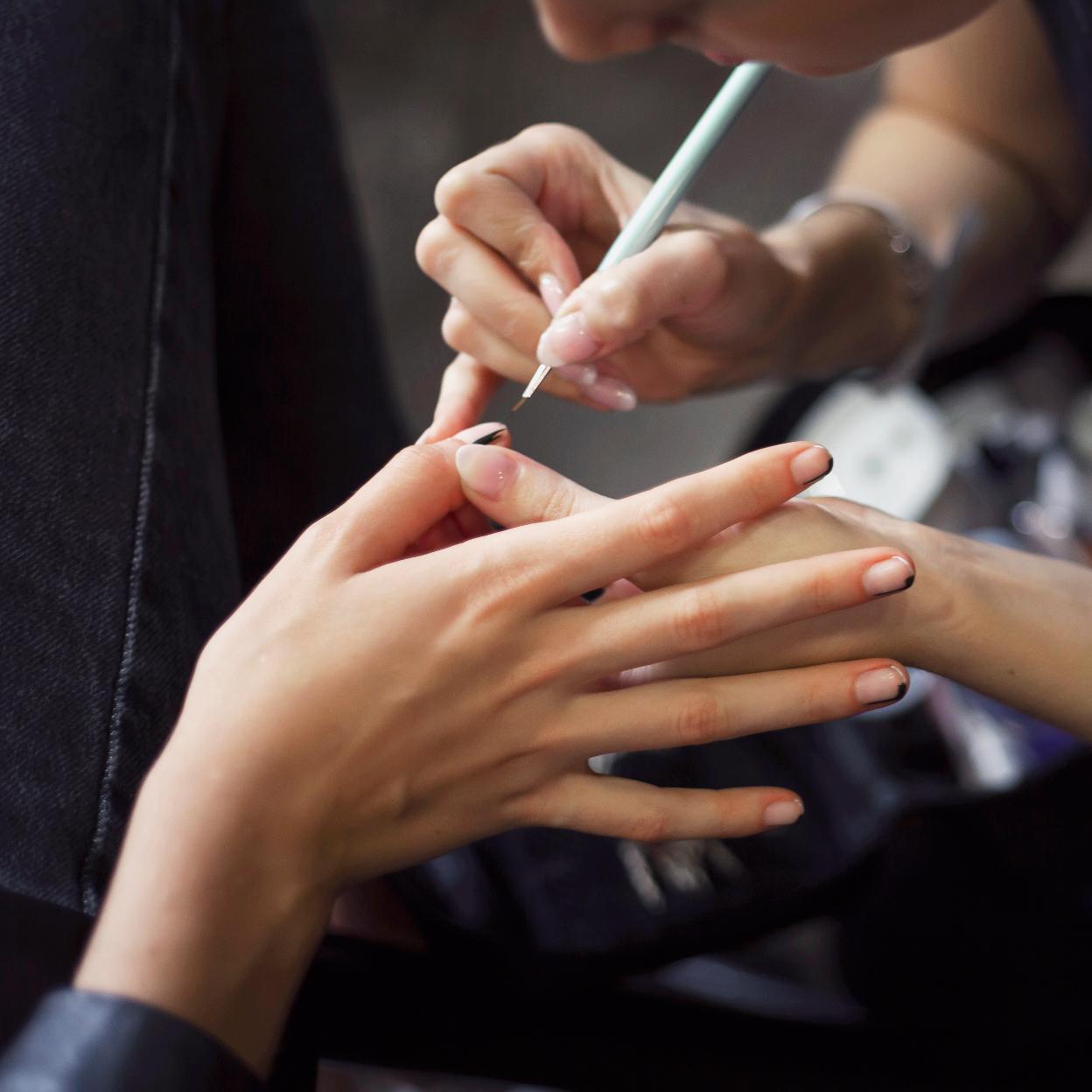 Una mujer haciéndose las uñas.