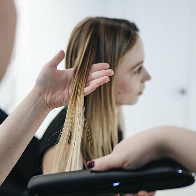 Mujer usando planchas de pelo