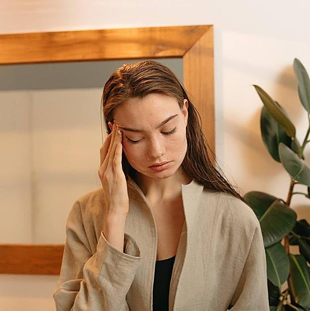Mujer aplicando crema con masaje en la frente