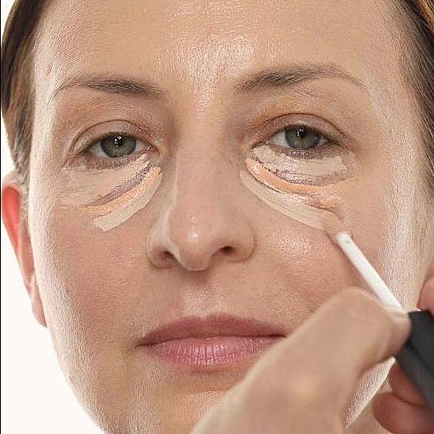 Mujer usando corrector y precorrector de ojeras