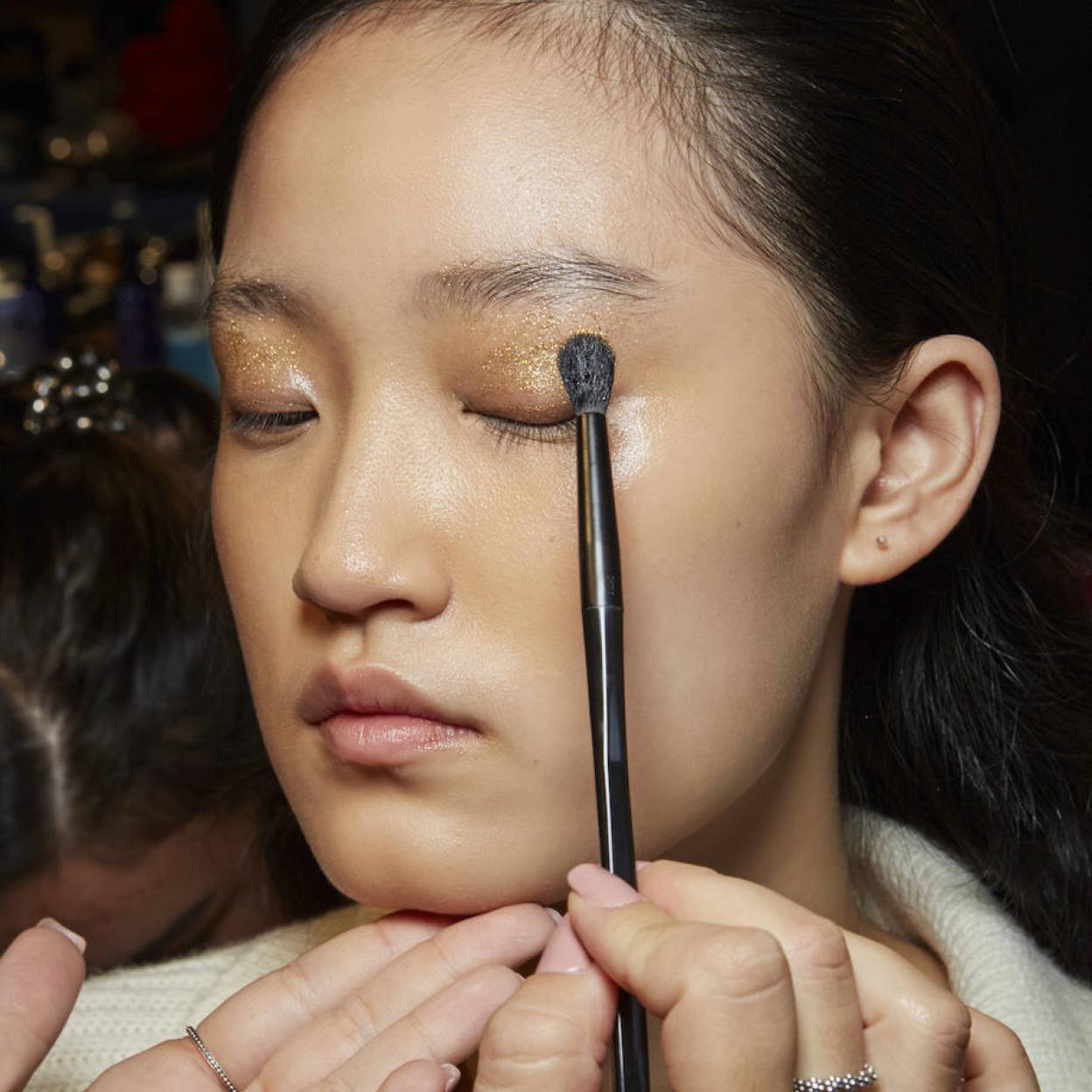 Maquilladora aplicando sombra de ojos