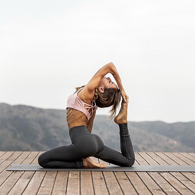 Mujer realizando yoga al aire libre.