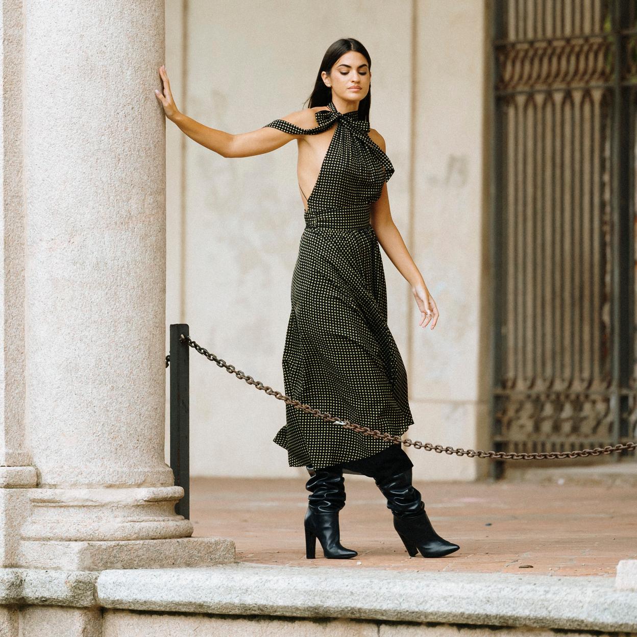 Una influencer con vestido midi y botas altas.