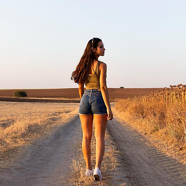 Mujer paseando por un camino. 