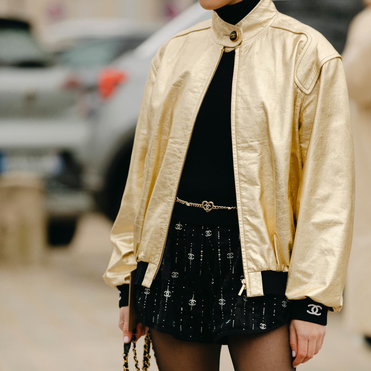 Una mujer con chaqueta bomber en dorado.