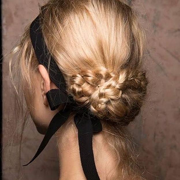 Modelo con peinado con trenzas romántico adornado por lazo