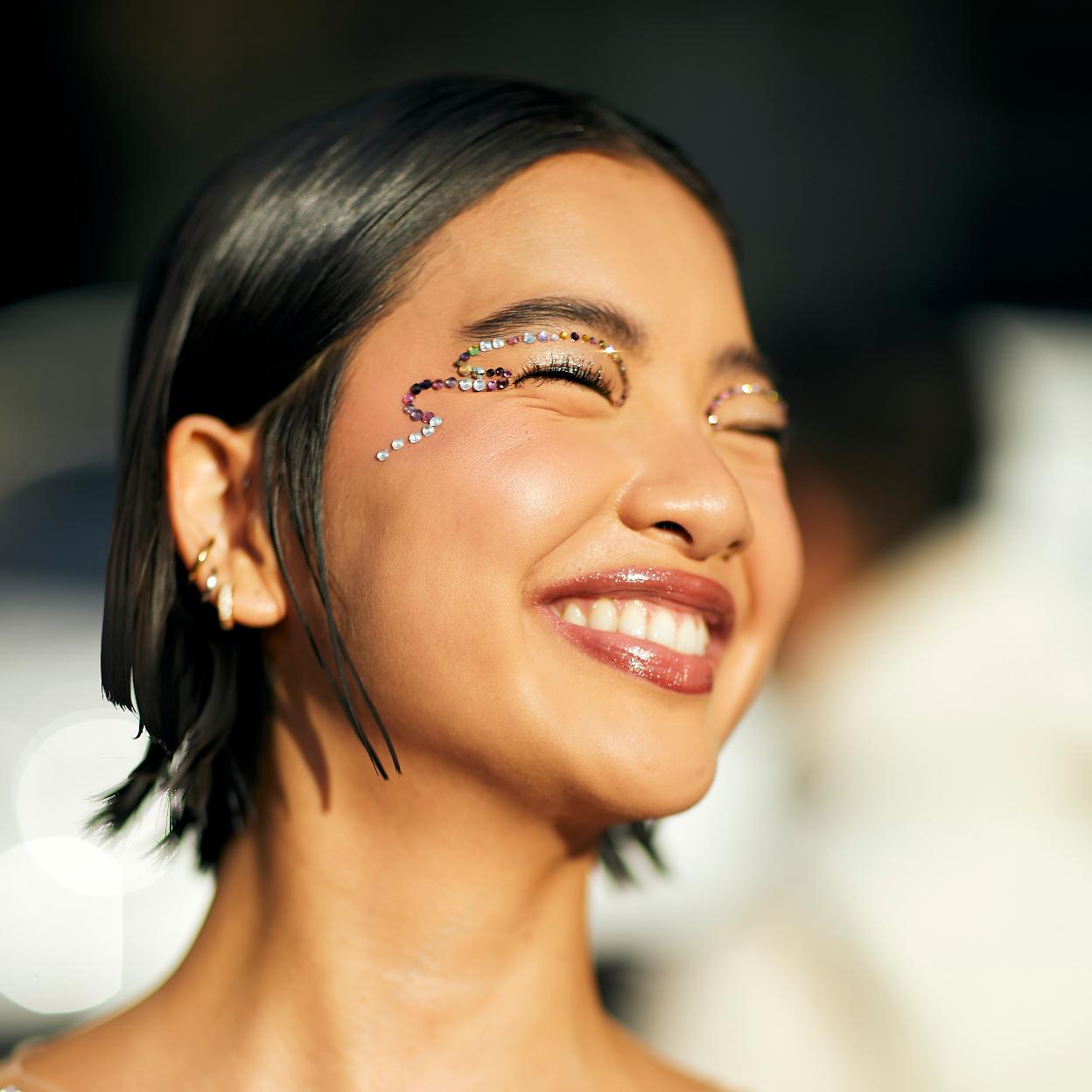 Una mujer con barra de labios en formato brillo.