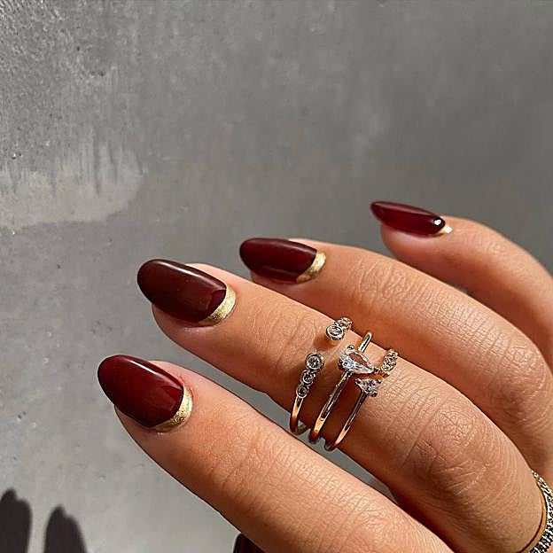 Manicura de uñas granates con detalles dorado