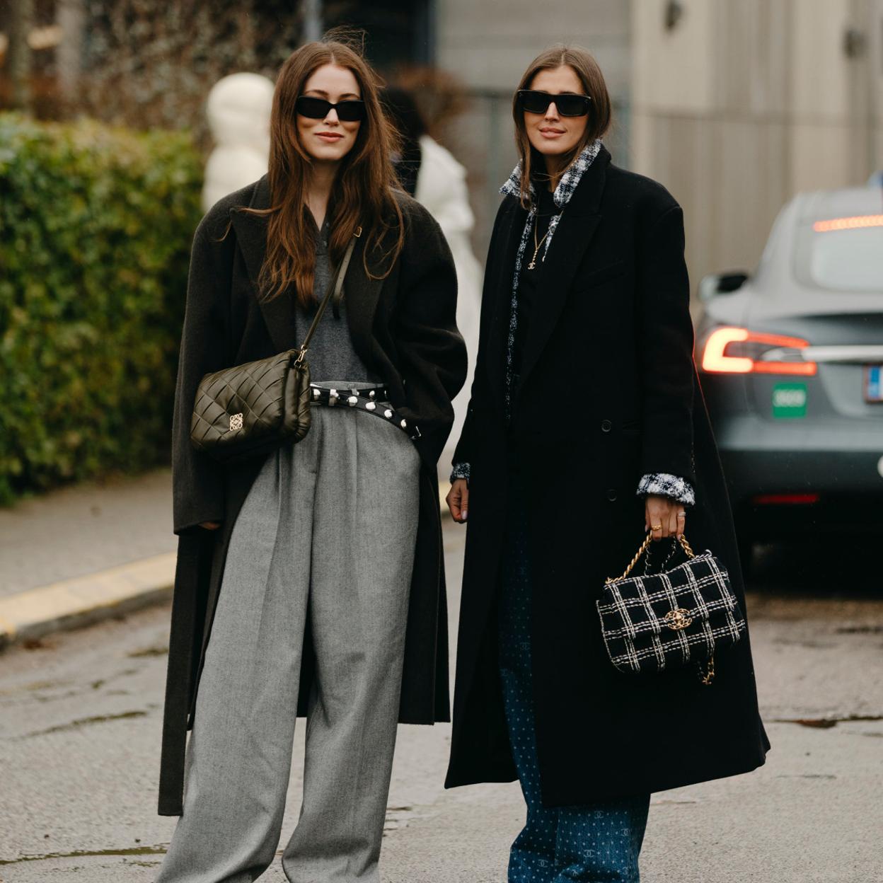 Dos mujeres con abrigo en color negro.