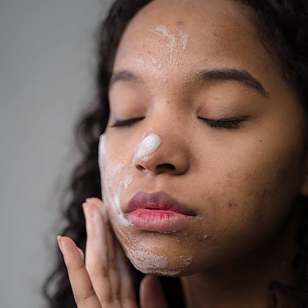 Mujer aplicando espuma limpiadora