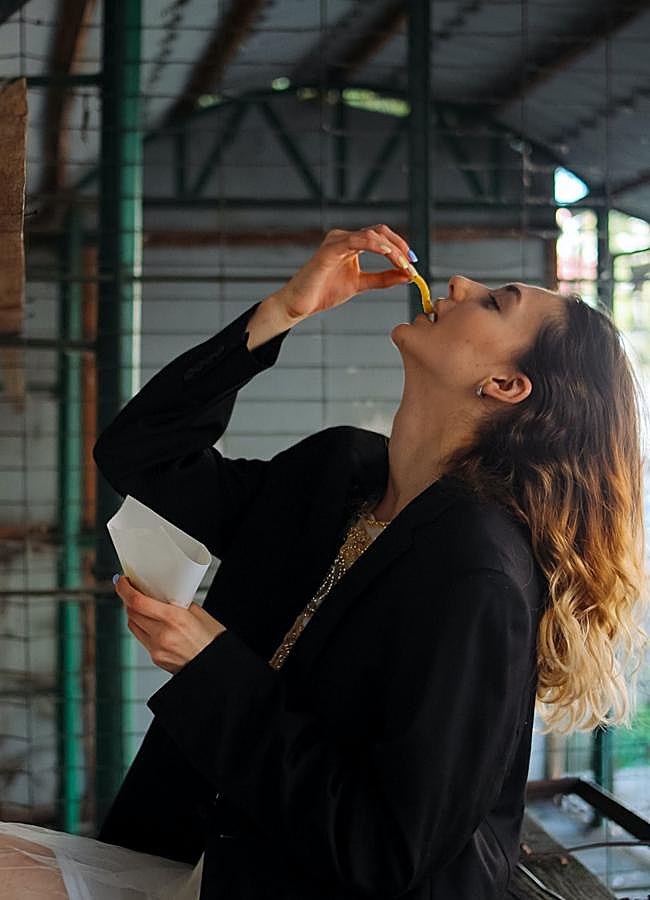 Imagen - Mujer comiendo patatas fritas/PEXELS