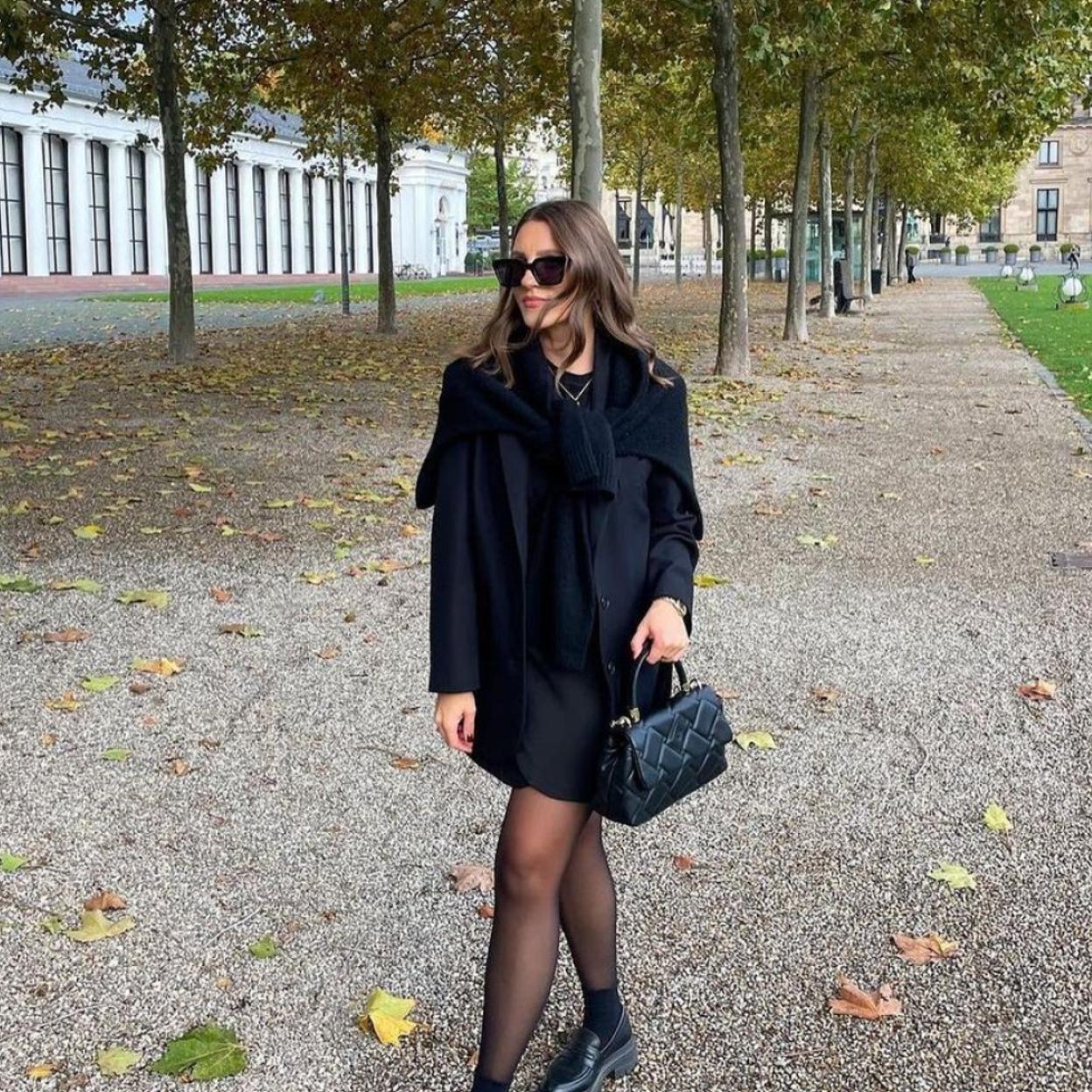 Una mujer con vestido negro de Zara.